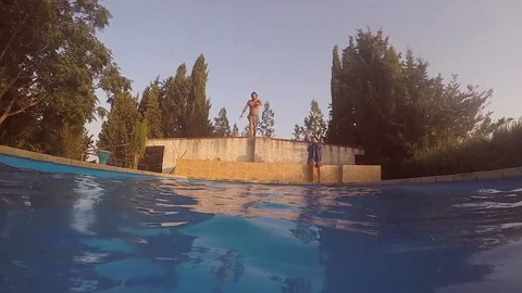 Attractive young man playing in a pool in summer Vidéo 106309922