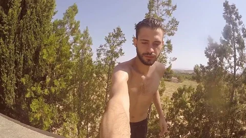 Attractive young man playing in a pool in summer 動画素材 106310087