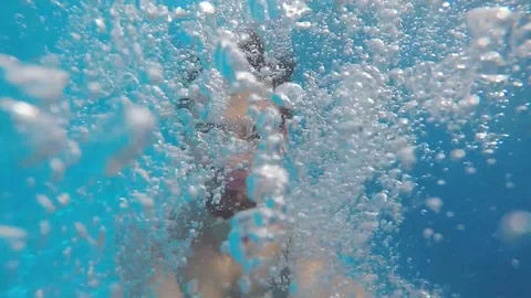 Attractive young man playing in a pool in summer 動画素材 106310109