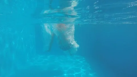 Attractive young man playing in a pool in summer 動画素材 106310114