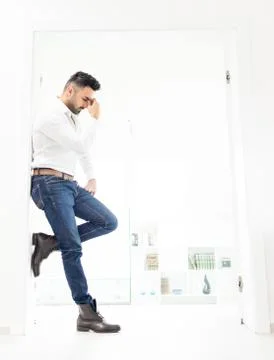 Attractive young man posing in white modern interior Stock Photos