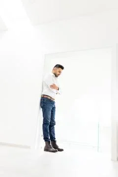Attractive young man posing in white modern interior Stock Photos