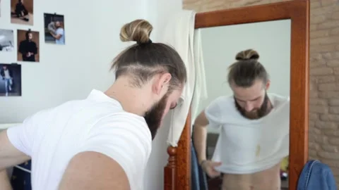 Attractive Young man Putting together an outfit wearing t-shirt with spot Stock Footage 147897403