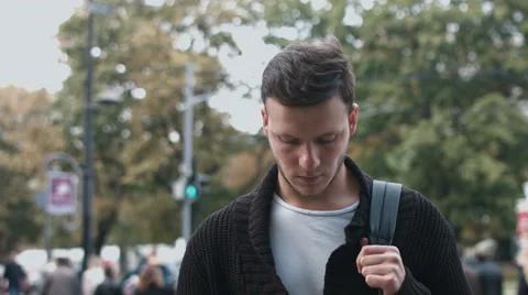 Attractive young man with serious gaze looking into the camera: 4k footage Stock Footage