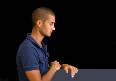 Attractive young man, side view, looking down with hands on board, Stock-Fotos