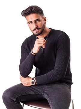 Attractive young man sitting on stool, wearing wool sweater Stock Photos