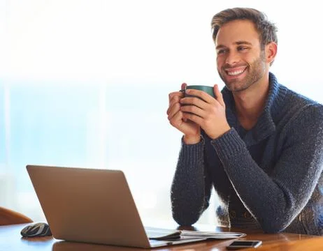 Attractive young man smiling while holding a coffee cup Stock-Fotos