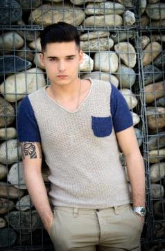 Attractive young man standing in front of stone wall Stock Photos