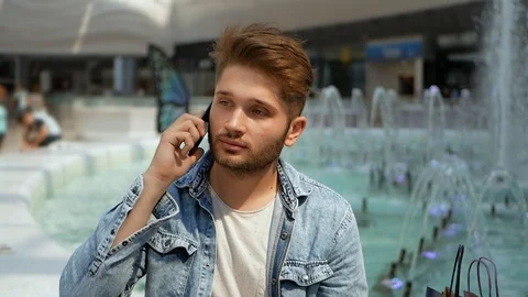 Attractive young man talking on mobile phone Video stock 95483478