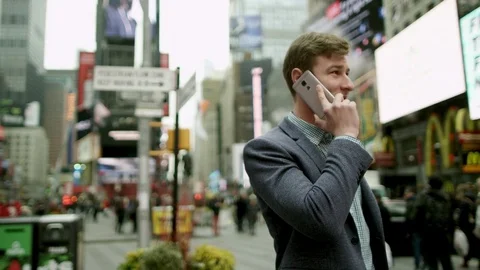 Attractive young man talking over his smartphone on Times Square Stock Footage 79593061