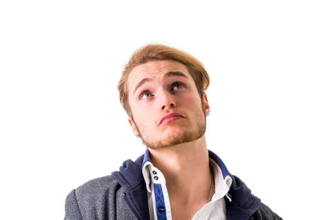 Attractive young man thinking, looking up unsure Stock Photos