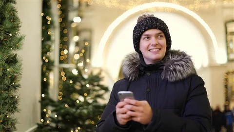 Attractive young man using app in smartphone on street in winter Stock Footage 101680848