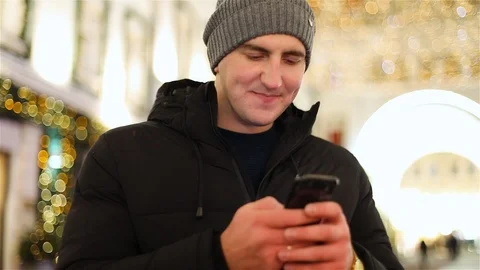 Attractive young man using app in smartphone on street in winter Video stock 101681000