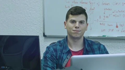 Attractive young man using computer at his working place. Office worker smiling Stock Footage 105808009