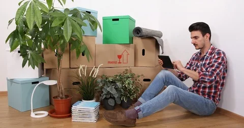 Attractive Young Man Using Digital Tablet Analyzing Objects Property in New Home Stock Footage 80097138