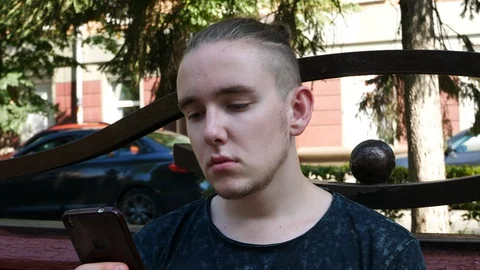 Attractive Young Man Using a Smartphone Stock Footage 114800661