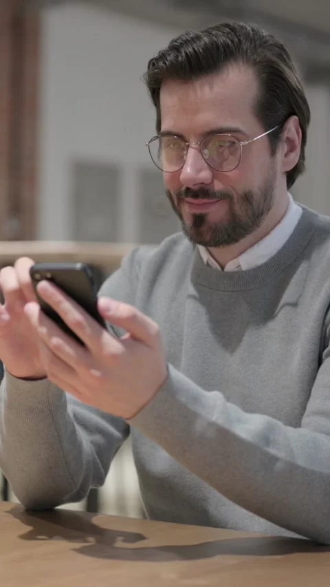 Attractive Young Man using Smartphone in Office, Vertical Video Video stock 339581100