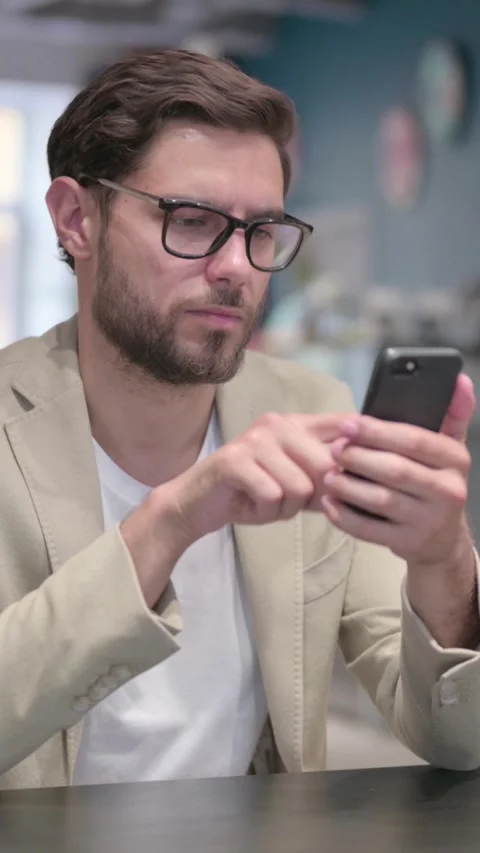 Attractive Young Man using Smartphone at Work, Vertical Video Stock Footage 342006435