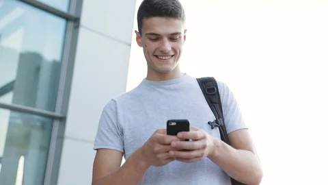 Attractive Young Man Walking it the City. Holding his Mobile Device.  Stock Footage 93034550