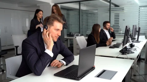 An attractive young man working in a call center with his colleagues Stock Footage 127422215