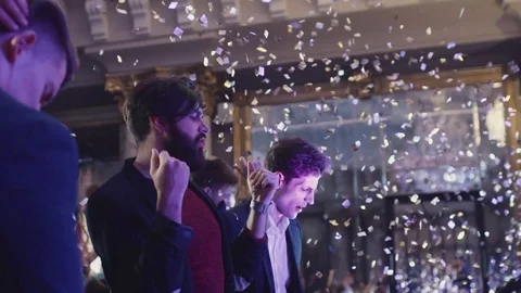 Attractive young men partying in the night club in confetti Stock Footage 69808853
