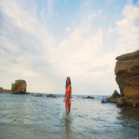 Attractive young model with cute curly hair posing in the beautiful desert beach Stock Footage 69497389