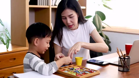 Attractive young mother multitask playing with kid boy while working on lap.. Stock Footage 246316633