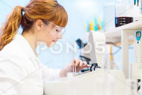 Attractive young scientist pipetting. Stock Photos
