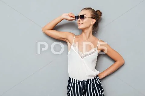 Attractive young smiling woman holding sunglasses Stock Photos