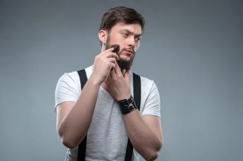 Attractive young strong man is shaving himself Stock Photos