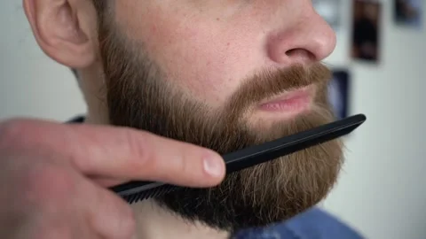 Attractive Young Stylish man is Combing His Beard close up Video stock 147900735