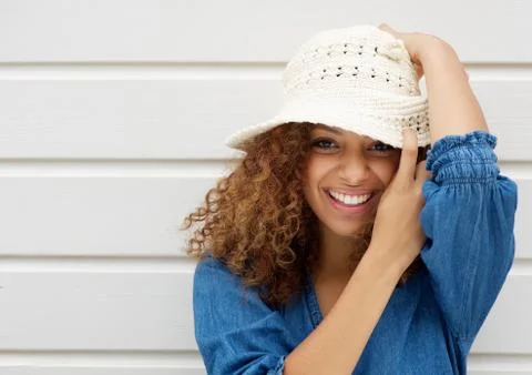 Attractive young woman smiling and wearing hat on white background Foto stock