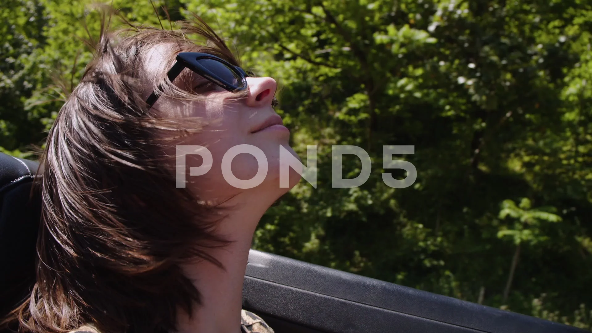 attractive young woman wearing sunglasses in sunlight