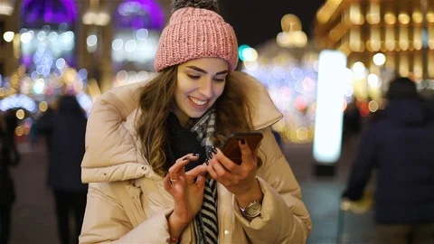 Attractive young woman using app in smartphone on street in winter Video stock 101863191