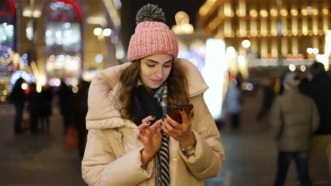 Attractive young woman using app in smartphone on street in winter Video stock 101863193