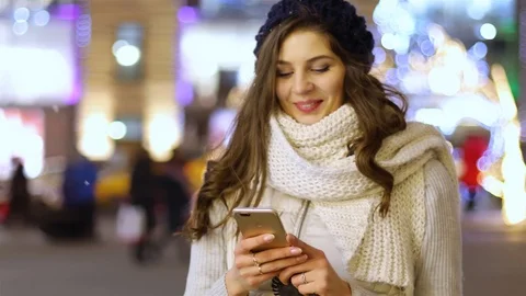 Attractive young woman using app in smartphone on street in winter Stock Footage 101863201