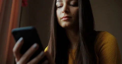 Attractive young woman using smart phone, typing on screen and surfing the Stock Footage 74313935