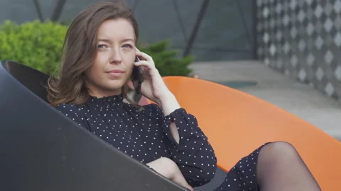Attractive young worker using a phone while relaxing in the green area 스톡 동영상 133096991