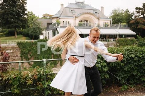 Attrective couple dance on the embanlment. Green background. Active pastime Stock Photos