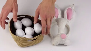 Attributes Easter - eggs and mask rabbit, human hand picks up basket with eggs Video stock 85509091