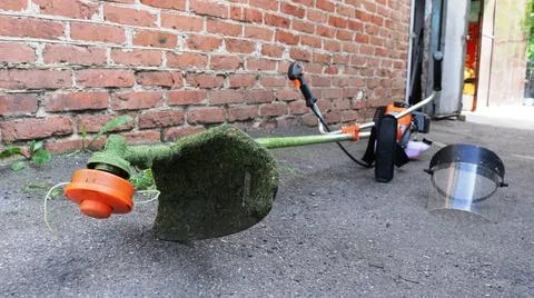 Attributes of a lawnmower on a brick wall background Stock Photos