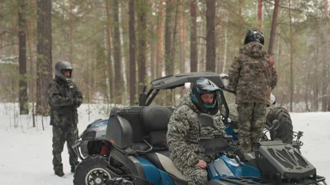ATV crew plans snowy trail. Riders gear up for icy journey. Snowcovered woodland Stock Footage 332167501