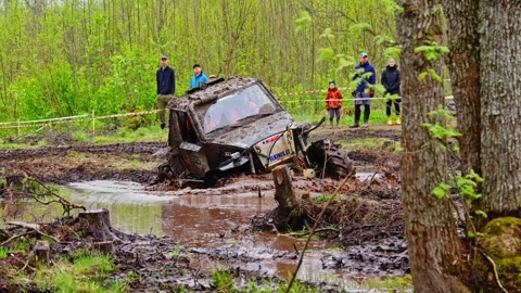 ATV drives into deep mud pocket and powers through obstacle Stock Footage 308999414