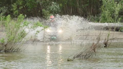 ATV drives into the river with a spray Vídeos de archivo 40545099
