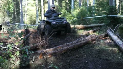 ATV driving over logs in the forest Stock Footage 10739976