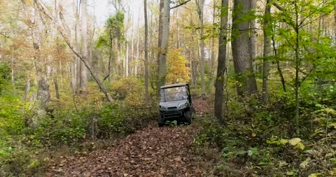 ATV driving through the woods during the fall, aerial drone footage Stock Footage 254498390