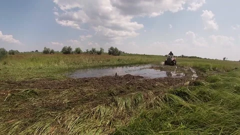ATV man drives through a puddle with bright splashes Stock Footage 159353115