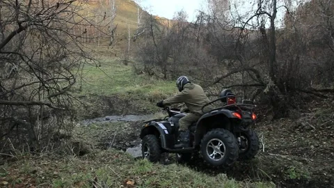 The ATV moves over an obstacle through a ravine with a river and mud. Vídeos de archivo 132934355