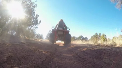 ATV Over Camera &amp; Away down Dirt Road- Slow Motion Stockbeeldmateriaal 312410278