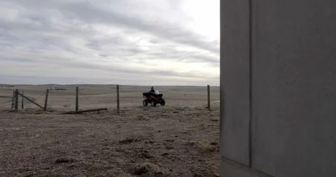 ATV Rider Pulling Up to Concrete Structure Stock Footage 100483010